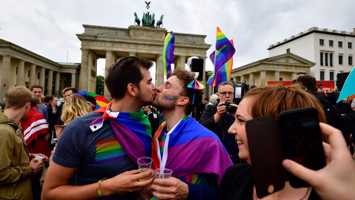 Two men kiss at a rally in front of the Brandenburg Gate in Berlin. German lawmakers on Friday voted to lift barriers to same-sex marriage.