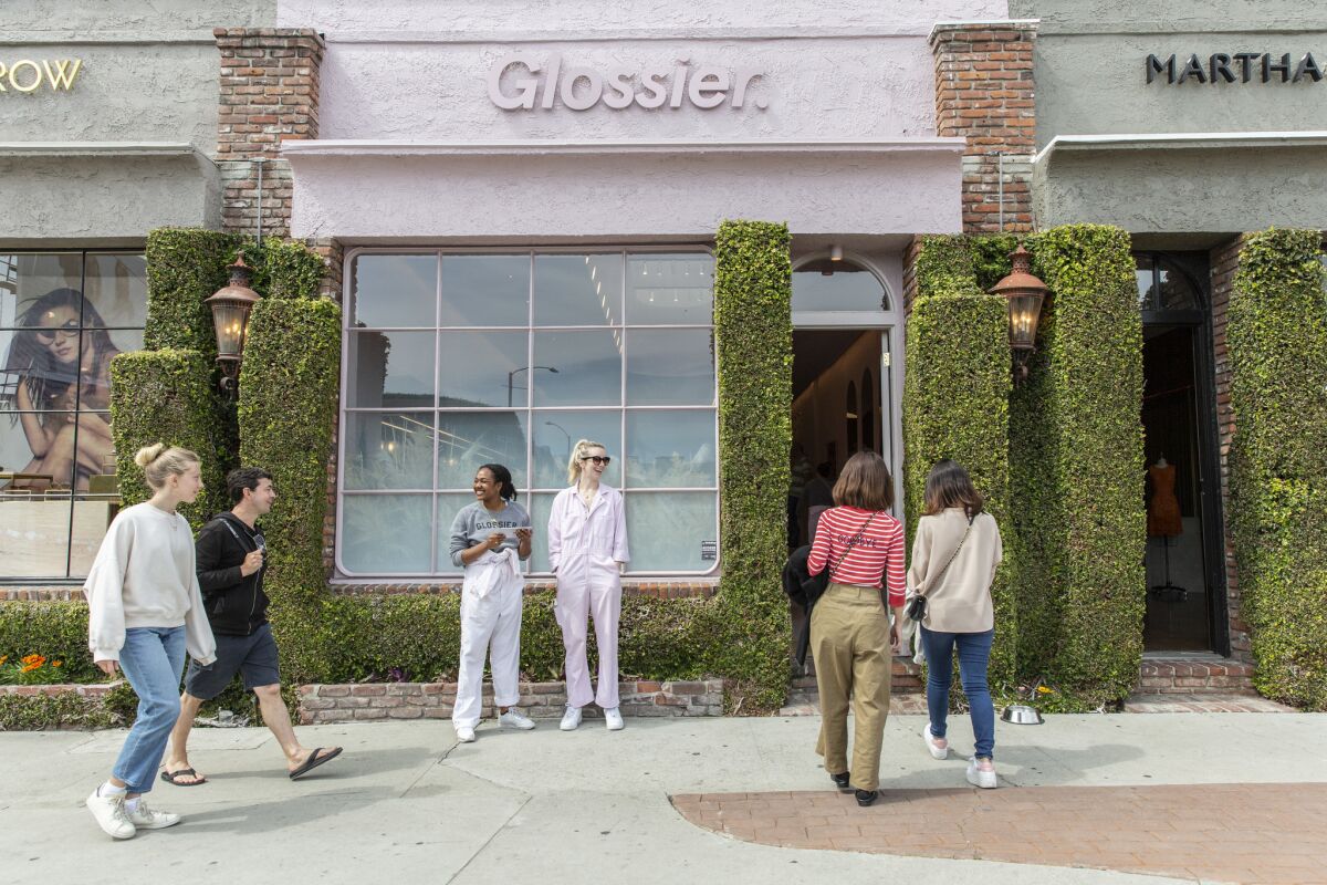 Shoppers head into the Glossier shop on Melrose Place.