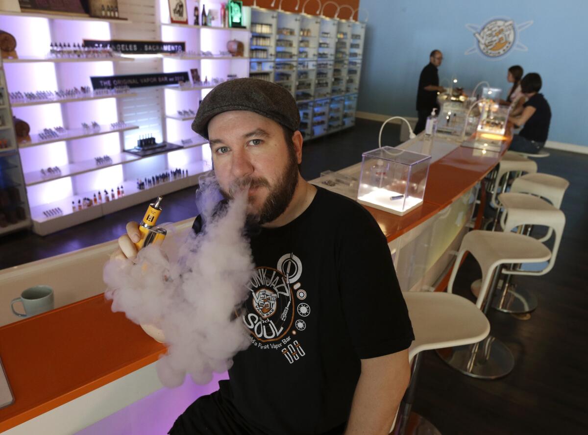 John "JJ' Jenkins, owner of the Vapor Spot exhales vapor from an e-cigarette while posing at his store in Sacramento, Calif. The Legislature failed to take up a bill to restrict vaping before it left for the year Friday.