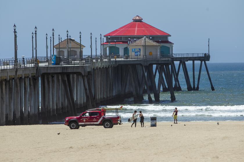 Lifeguards patrol the beach near the Huntington Beach Pier on Tuesday, May 5.