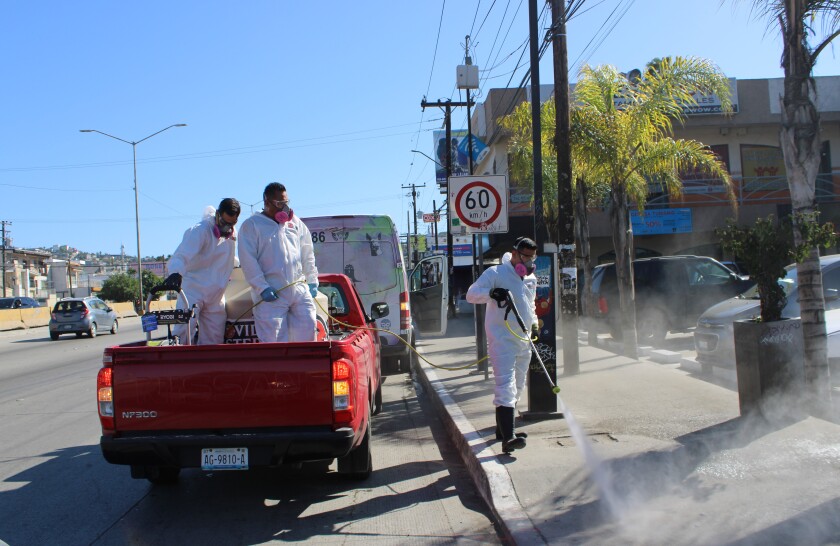 Integrantes de los "Covid Busters" durante una jornada sobre la 5 y 10 de Tijuana.
