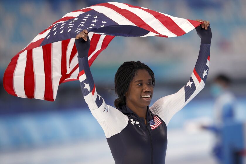 U.S. speed skater Erin Jackson takes a victory lap with an American flag after winning a gold.