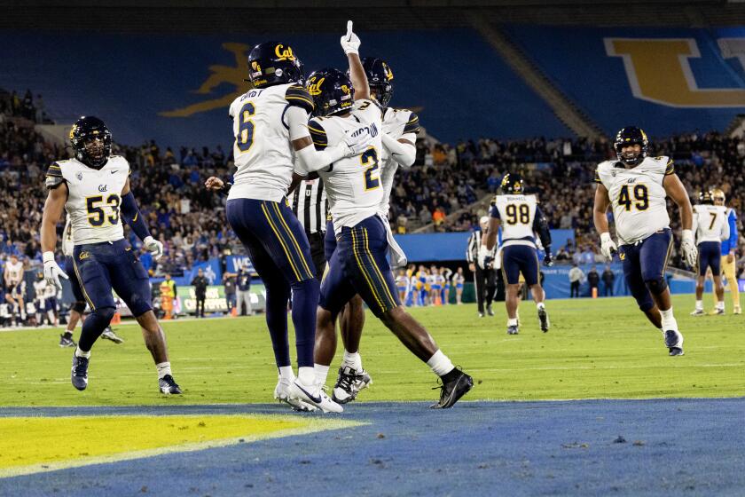 PASADENA, CA - NOVEMBER 25, 2023: California Golden Bears defensive back Craig Woodson (2) reacts with teammates after intercepting a pass thrown by UCLA Bruins quarterback Dante Moore (3) in the first quarter at the Rose Bowl on November 25, 2023 in Pasadena, California.(Gina Ferazzi / Los Angeles Times)
