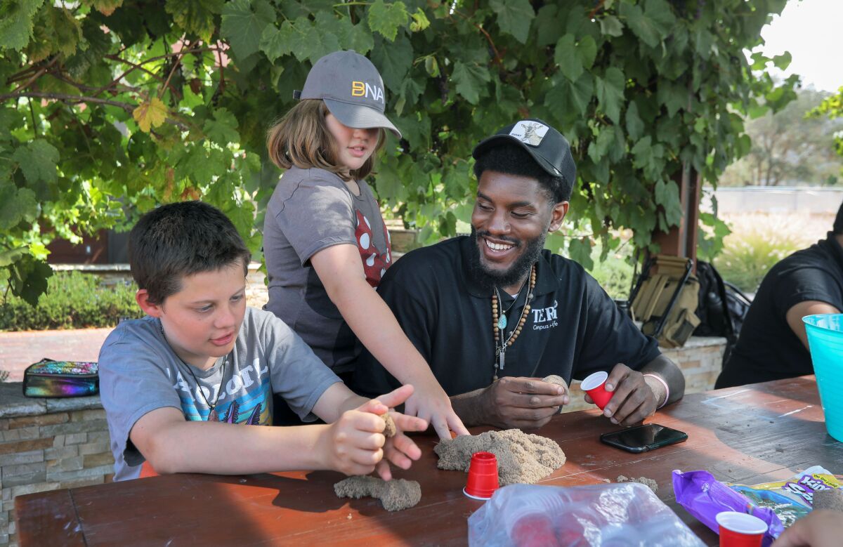 Instructional aide Keith Houston works on a craft project with Brodie Head, 11, and Zoey Head.