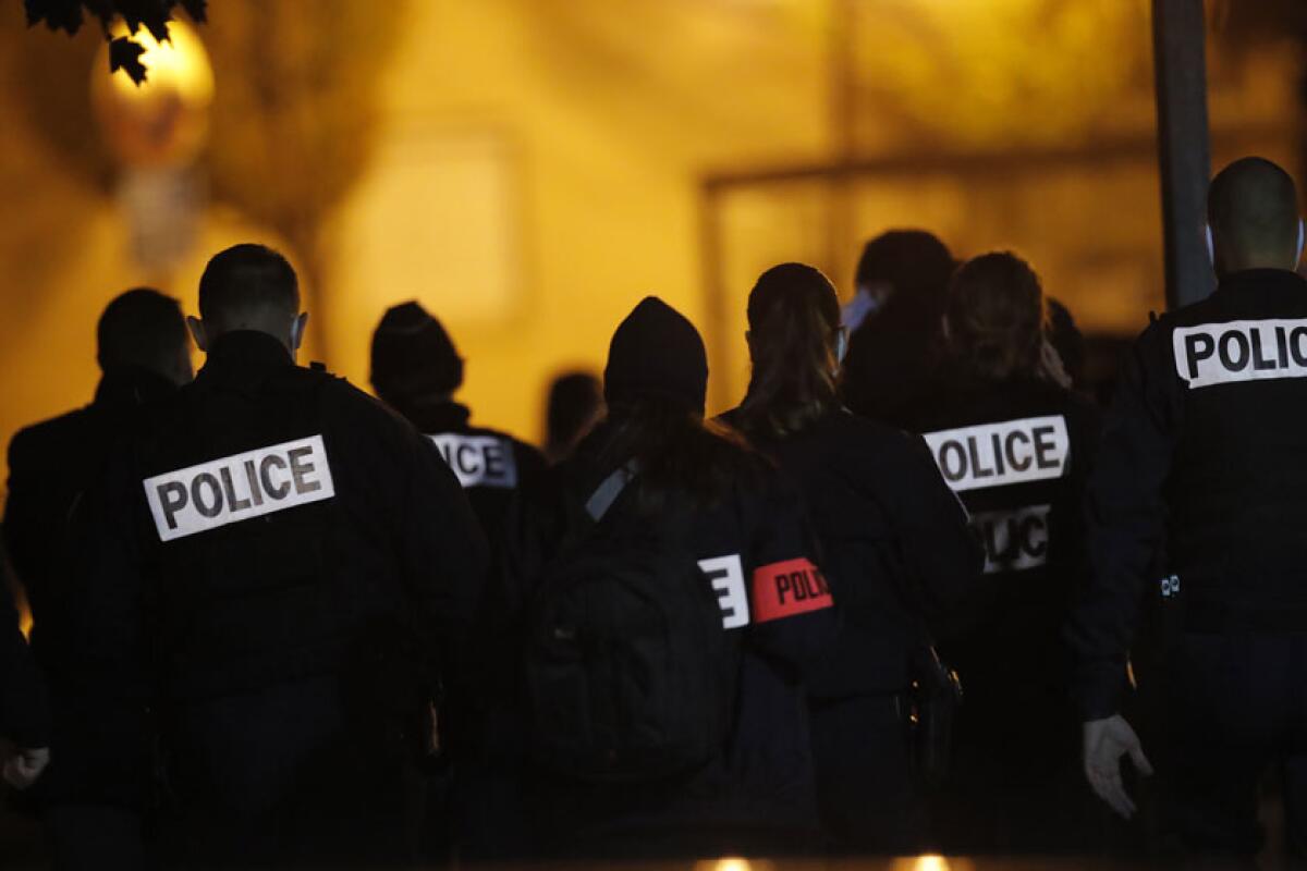 French police officers gather outside a high school near Paris after a history teacher was beheaded Friday.