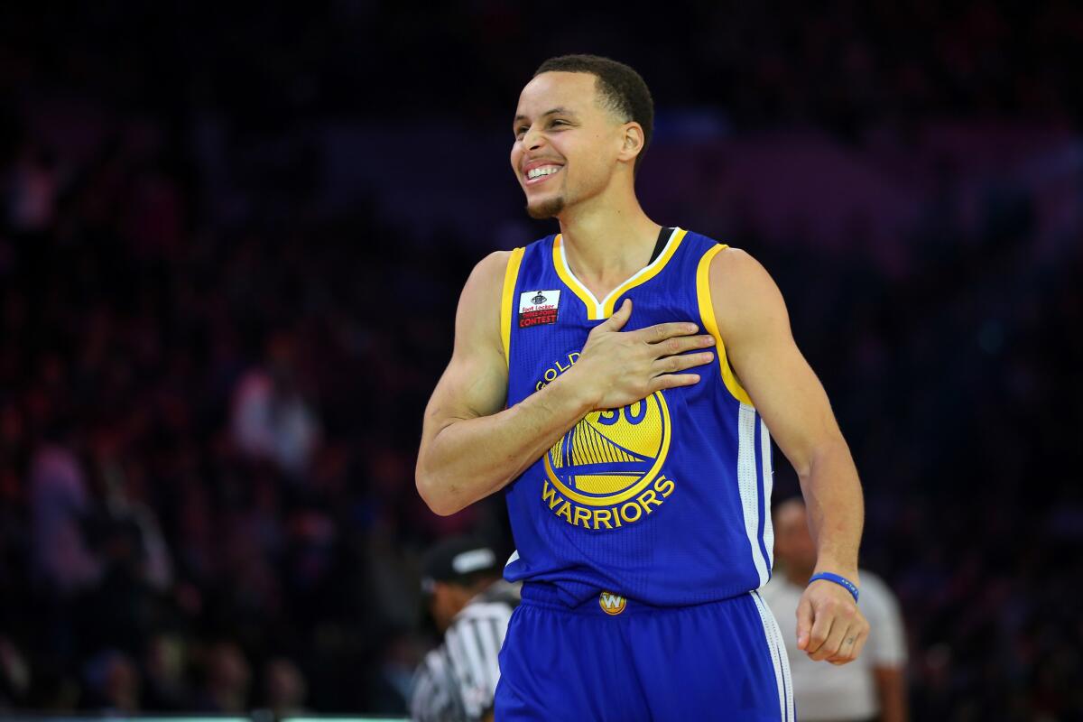 Warriors point guard Stephen Curry celebrates after winning the three-point shooting contest on Saturday during the NBA All-Star Weekend competitions.