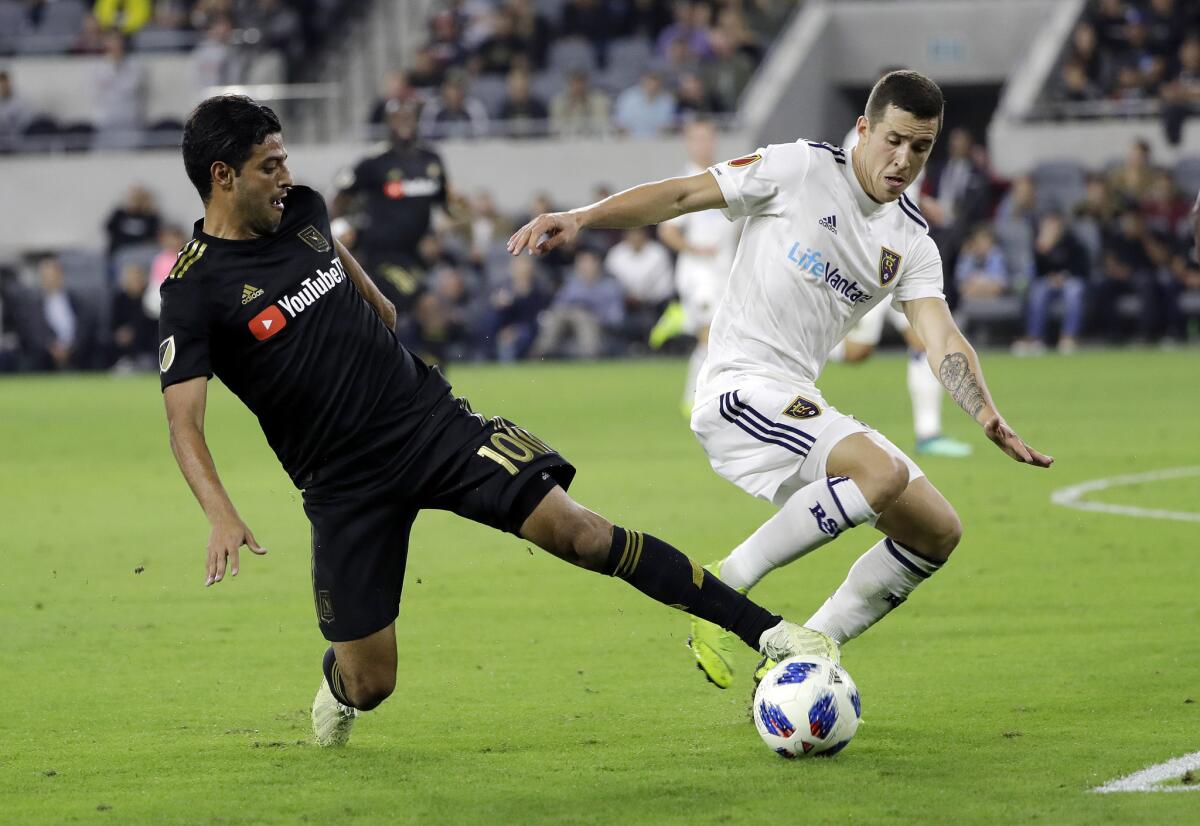 Los Angeles FC's Carlos Vela, left, is defended by Real Salt Lake's Aaron Herrera during the first half of an MLS soccer playoff match Thursday, Nov. 1, 2018, in Los Angeles.