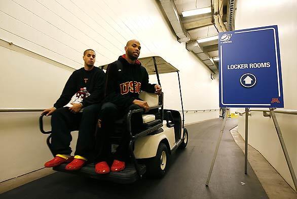 USC teammates Daniel Hackett, left, and Taj Gibson hitch a ride to the locker room as the team prepares for Friday's first-round NCAA tournament game against Boston College at the Metrodome.