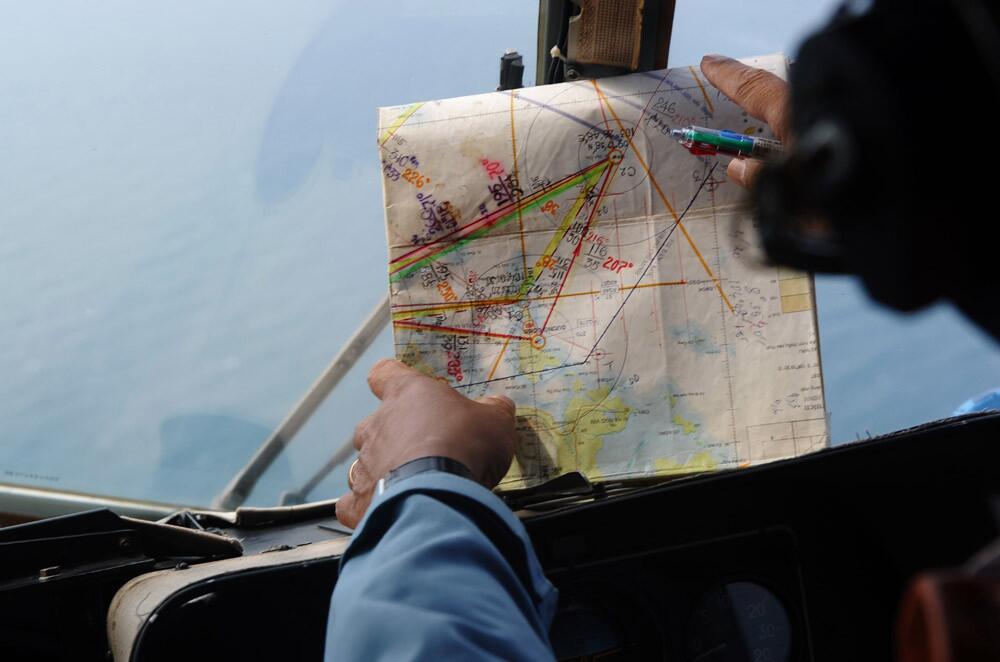 This picture taken aboard a Vietnamese Air Force Russian-made MI-171 helicopter shows a crew member checking a map during a search over the southern Vietnamese waters off Vietnam's island Phu Quoc on March 11.