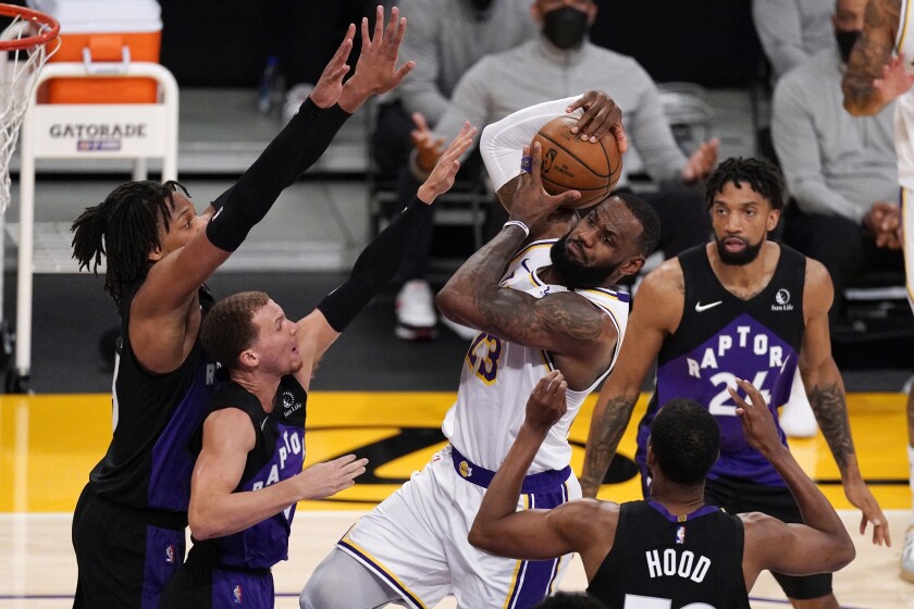 Los Angeles Lakers forward LeBron James, center, tries to shoot as Toronto Raptors forward Freddie Gillespie, left, guard Malachi Flynn, second from left, guard Rodney Hood, second from right, and center Khem Birch defend during the first half of an NBA basketball game Sunday, May 2, 2021, in Los Angeles. (AP Photo/Mark J. Terrill)