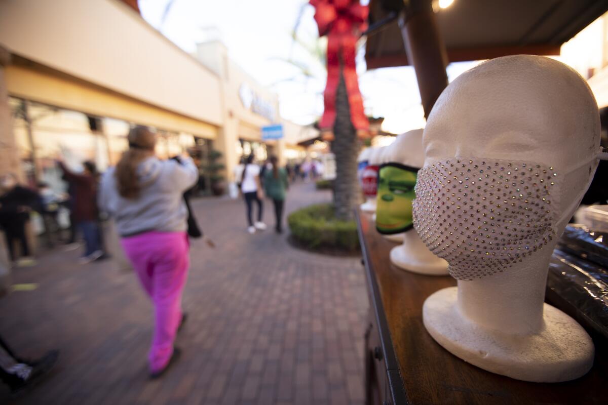 Masks on mannequin heads at a kiosk at an outdoor mall