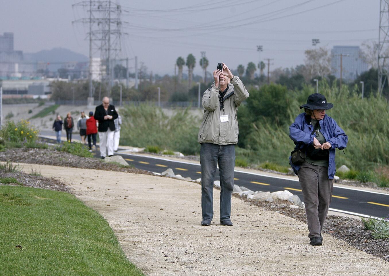 Bob Thompson takes a photo while Jeanne LeFever looks around during the grand opening of the Glendale Narrows Riverwalk in Glendale on Wednesday, December 12, 2012. Phase 1 of the project opened today at the corner of Paula and Garden Streets in Glendale with a ribbon cutting ceremony.