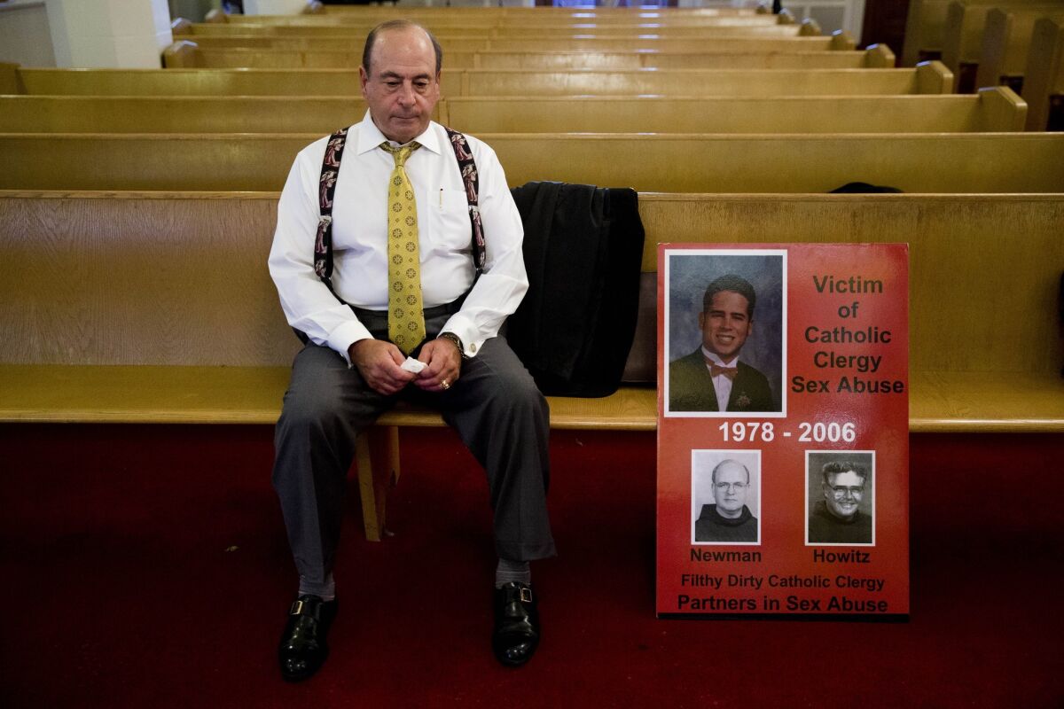 Arthur Baselice, the father of Arthur Baselice III, pictured in poster, sits on a pew after a news conference in Philadelphia last week. Baselice said his son was abused by a priest and a religious brother, became addicted to drugs and killed himself. Baselice said the Vatican needs to find ways to hold church leaders accountable for sheltering predators.