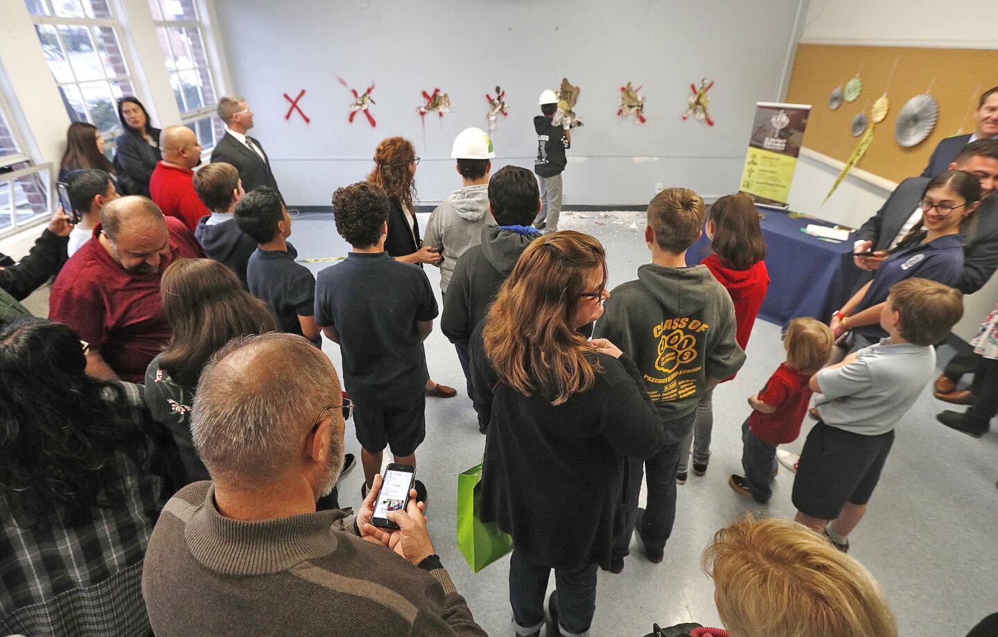 Parents and guests to the school watch the first new students to the school swing a sledge hammer into a wall labeled for demolition on the first day inside the St. John Paul II STEM Academy at Bellarmine-Jefferson, a new Roman Catholic high school in Burbank on Monday, March 4, 2019. The school will open to a small class of freshman in the Fall, focussing on science, technology, engineering, and math.
