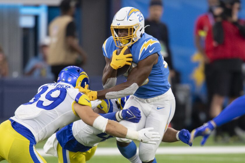 Los Angeles Chargers running back Joshua Kelley (25) is tackled by Los Angeles Rams safety Jake Gervase.