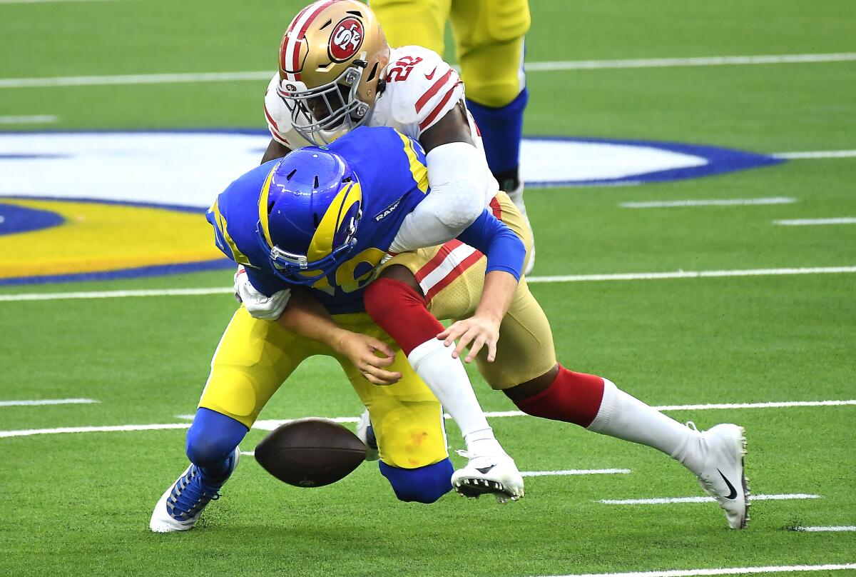 Rams quarterback Jared Goff fumbles the ball as 49ers defensive back Jimmie Ward tackles him.