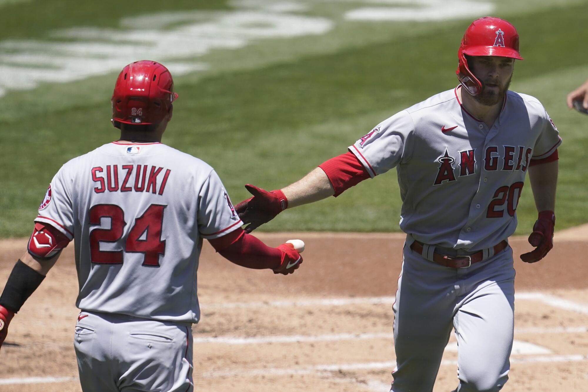 Jared Walsh, right, is congratulated by Angels teammate Kurt Suzuki after hitting a solo home run.