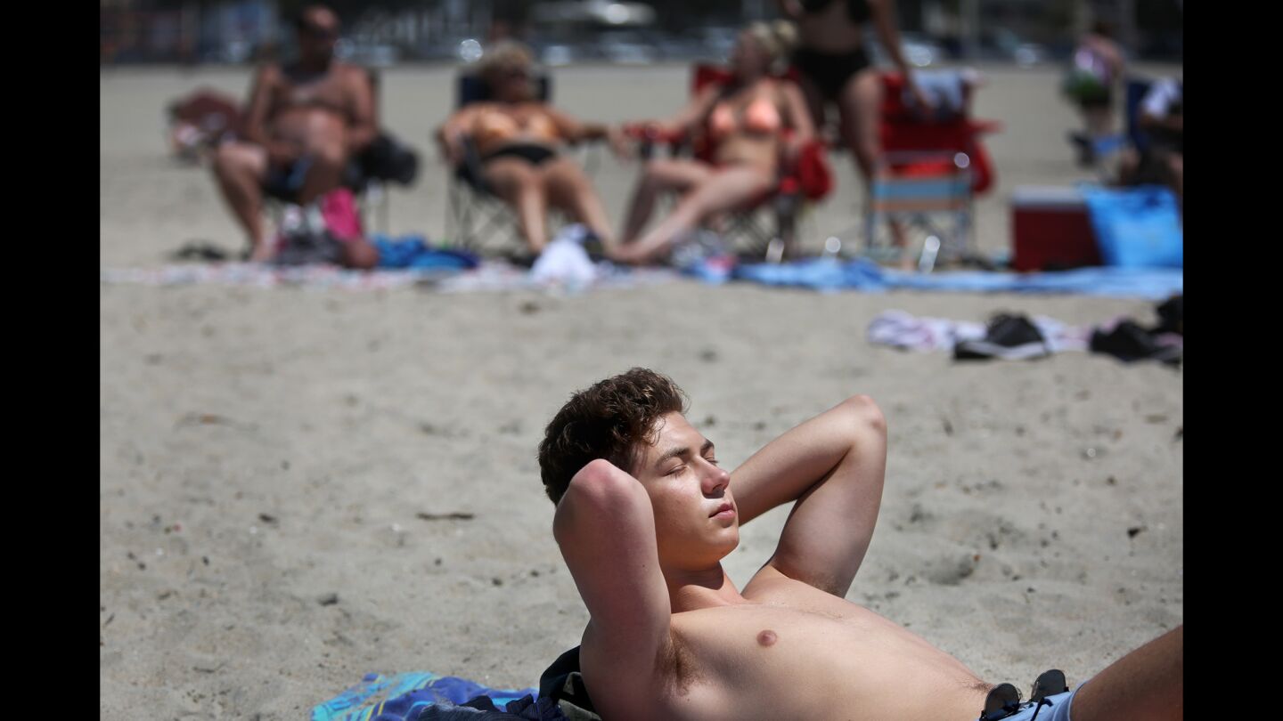 Jack Amsbry, 18, of Pasadena soaks up a warm beach breeze in Long Beach.