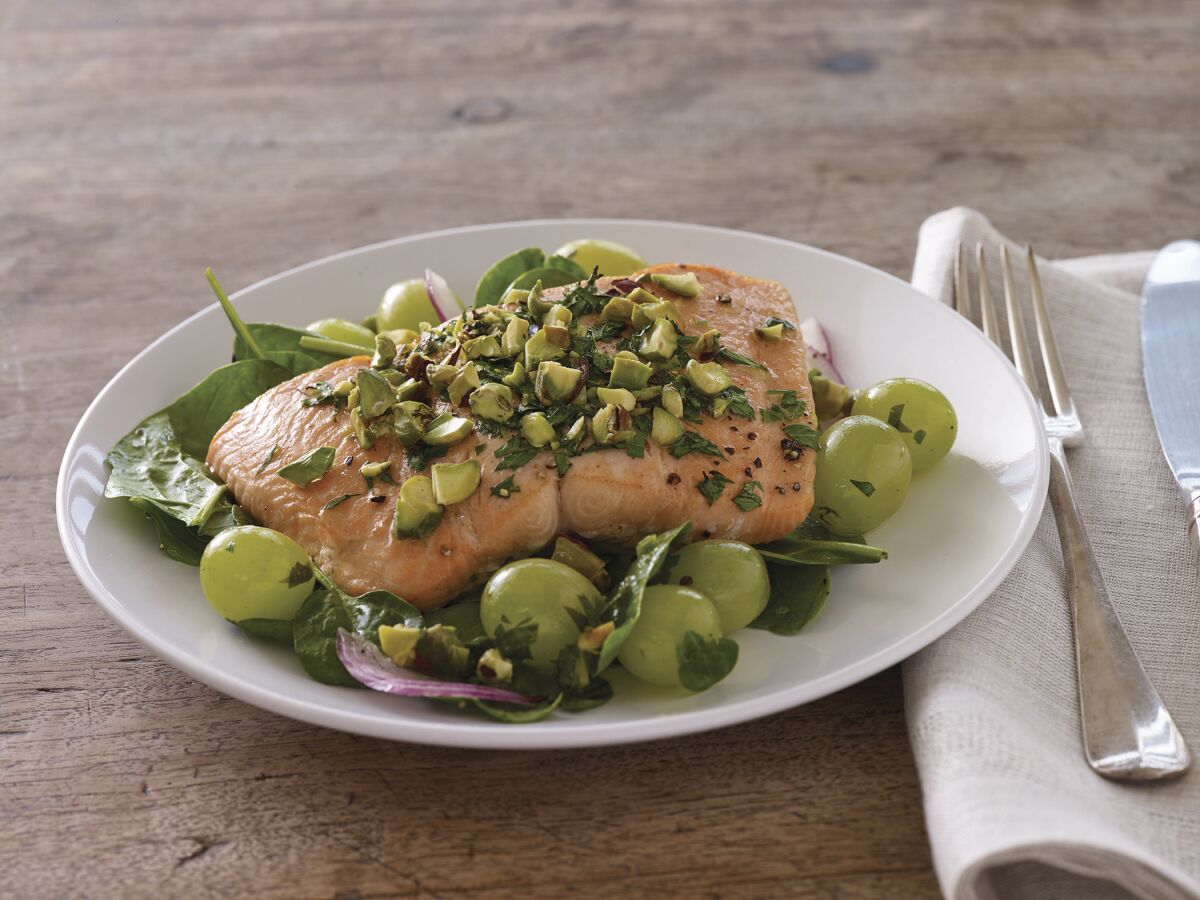 Roasted salmon with grapes and pistachios over fresh greens