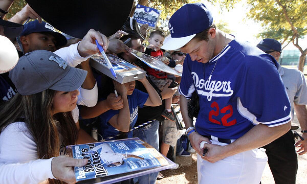 Dodgers pitcher Clayton Kershaw signs autographs for fans at the team's spring training facility in Glendale, Ariz., on Feb. 10.