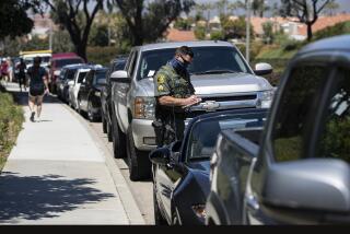 DANA POINT, CALIFORNIA - APRIL 25, 2020: An Orange County Sheriff Deputy tickets vehicles parked in a "No Parking" zone on Stonehill Drive as residents were parking there to walk to Salt Creek Beach during the coronavirus pandemic on April 25, 2020 in Dana Point, California. One resident told a deputy, "I'll pay the $30 ticket. I just want to surf."(Gina Ferazzi/Los Angeles Times)