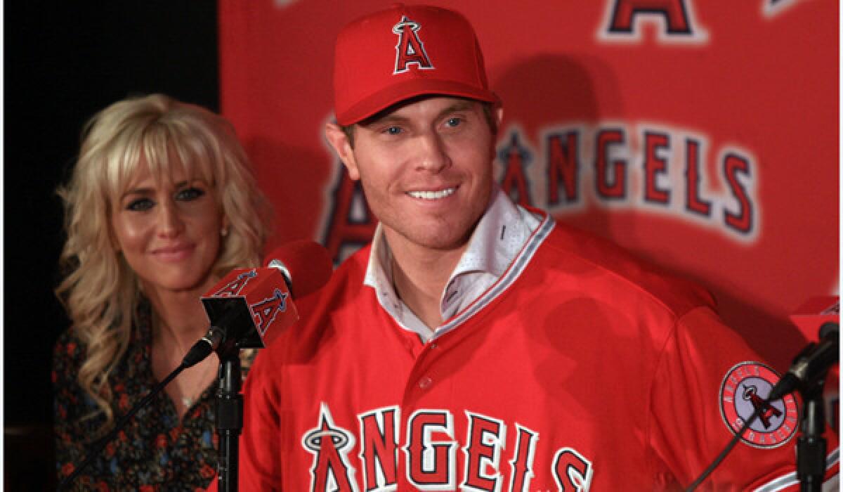 Outfielder Josh Hamilton stands next to his wife Katie Hamilton after donning a bright red Angels jersey with his familiar No. 32 for the first time Saturday at ESPN Zone in Anaheim.