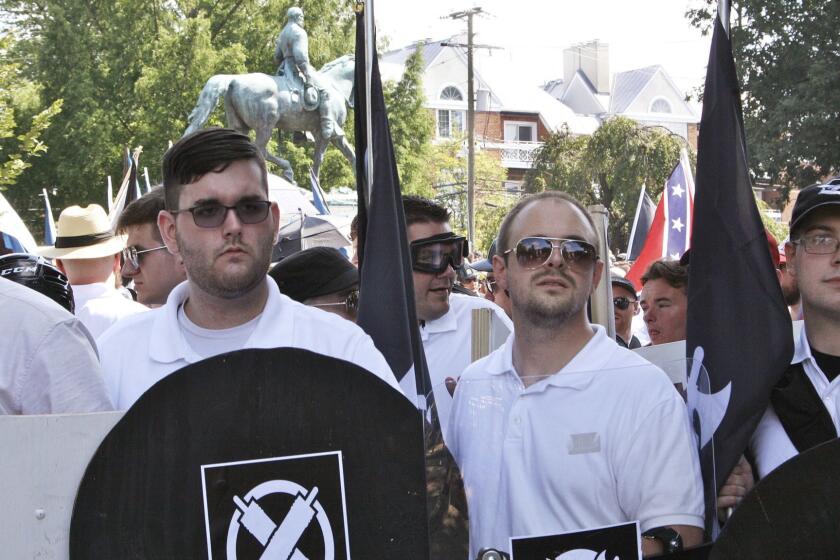 In this Saturday, Aug. 12, 2017 photo, James Alex Fields Jr., second from left, holds a black shield in Charlottesville, Va., where a white supremacist rally took place. Fields was later charged with second-degree murder and other counts after authorities say he plowed a car into a crowd of people protesting the white nationalist rally. (Alan Goffinski AP)