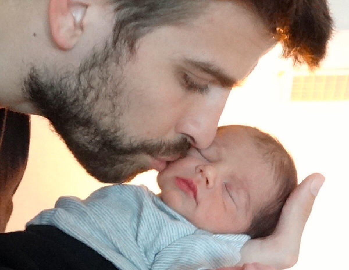 Gerard Pique kisses he and Shakira's baby boy, Milan.