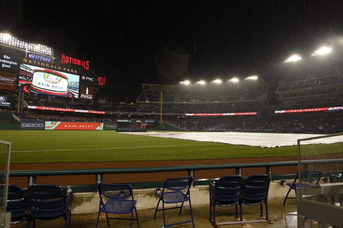 The tarp lies on the field during a rain delay between the Dodgers and Washington Nationals on Saturday.