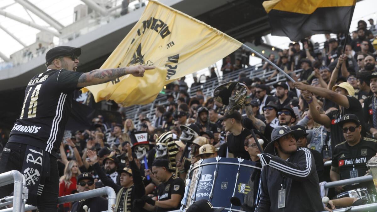 Jimmy Lopez, left, joins fans in a cheer before LAFC's game against the Seattle Sounders in the first game at the brand-new Banc of California Stadium.