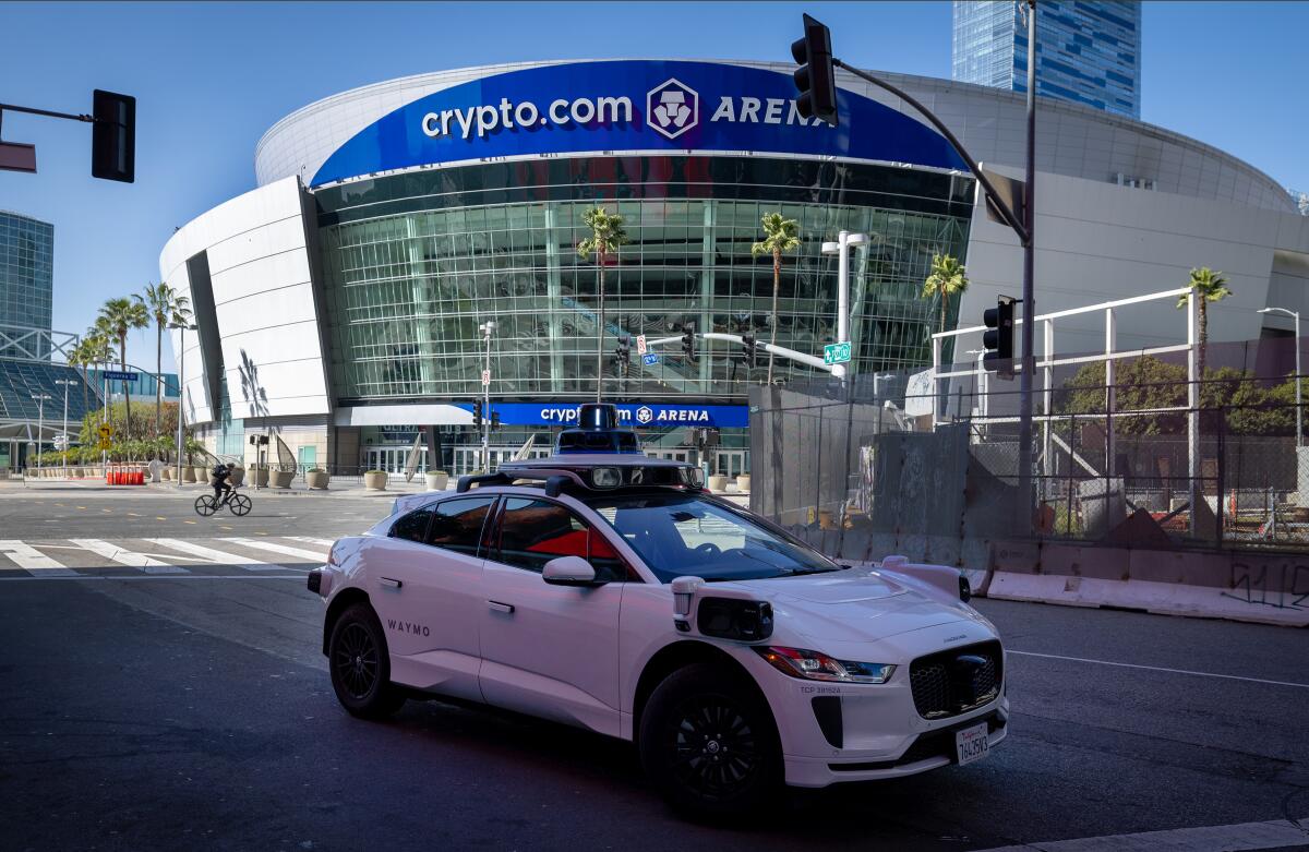 A Waymo robotaxi makes a stop near Crypto.com Arena in downtown Los Angeles on March 11. 