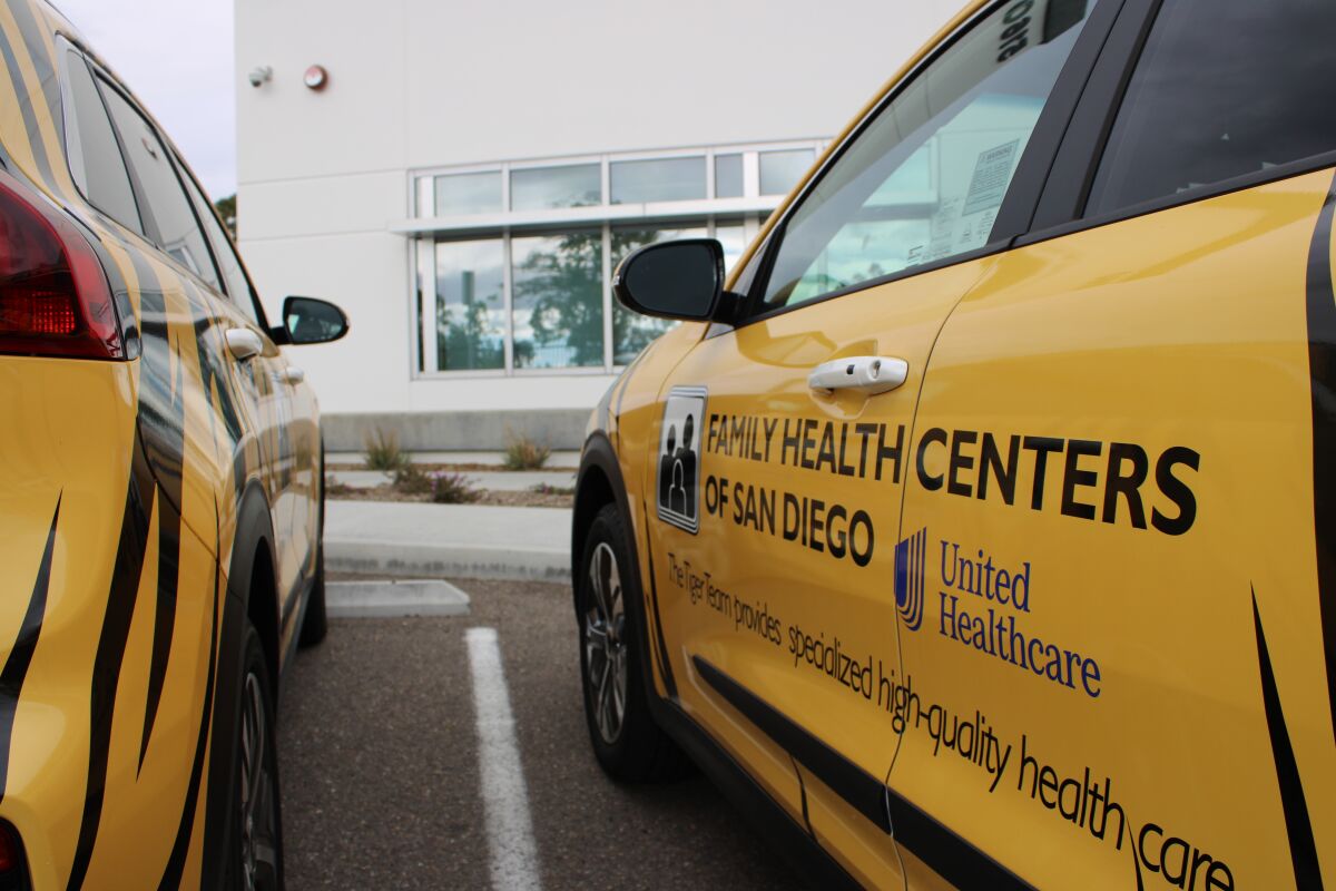 Two yellow electric vehicles are used as part of the Tiger Team program from Family Health Centers of San Diego