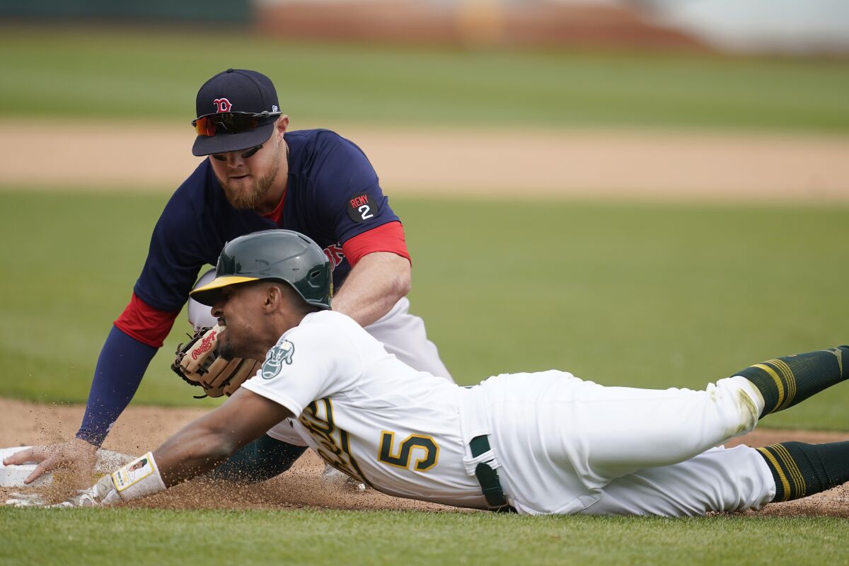 Boston Red Sox third baseman Bobby Dalbec, top, tags out Oakland Athletics' Tony Kemp (5) at third during the eighth inning of a baseball game in Oakland, Calif., Saturday, June 4, 2022. (AP Photo/Jeff Chiu)