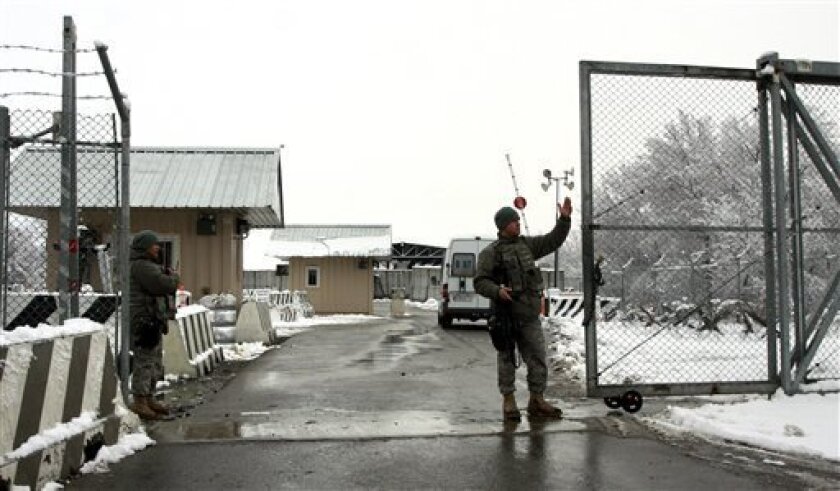 U.S. soldiers open the gates of a military base, which is located within Manas civilian airport, near Kyrgyzstan's capital Bishkek Wednesday, Feb. 4, 2009. Kyrgyzstan's government submitted a draft bill to parliament Wednesday to revoke the country's hosting of a U.S. base that is an important component of the Afghanistan military campaign. (AP Photo/Igor Kovalenko)