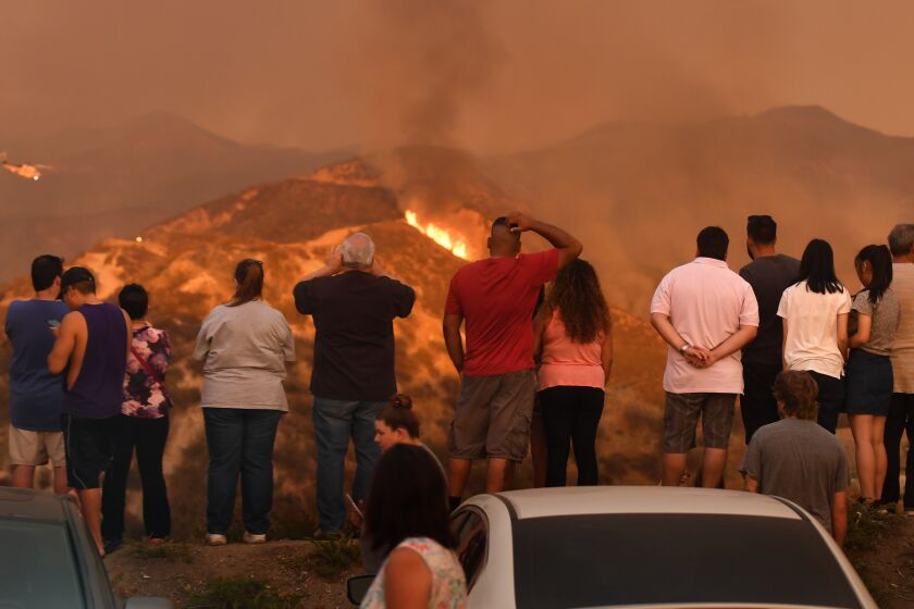 Evacuated residents watch as the Sand fire burns through the San Gabriel Mountains on Sunday.