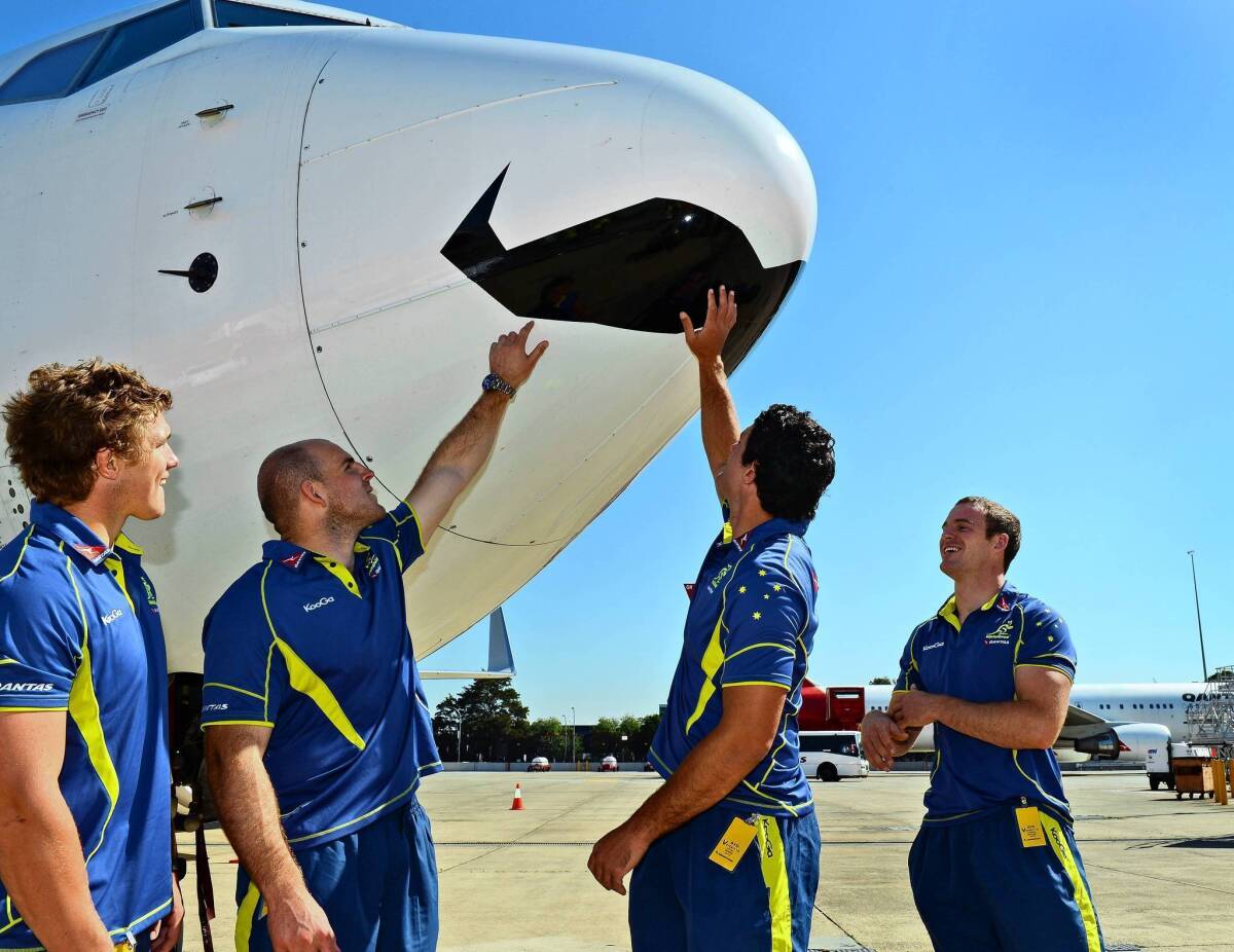 Australian rugby players Michael Hooper, left, Stephen Moore, Dave Dennis and Pat McCabe admire a Qantas jetliner with a mustache painted in its nose to mark Movember, the worldwide fundraiser to help fight prostate cancer.