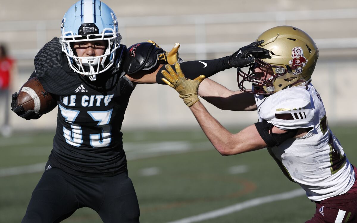University City's Jayden Daly (33) stiff-arms Point Loma's Cameron Lucas (20) during the Division III title game on Friday.