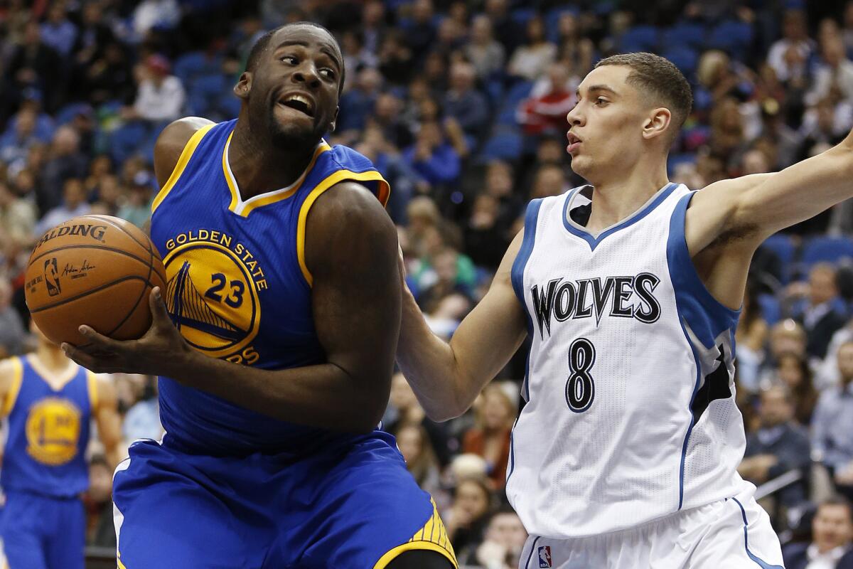 Golden State forward Draymond Green is defended by Minnesota guard Zach LaVine during the second half of the Warriors' 102-86 win over the Timberwolves.