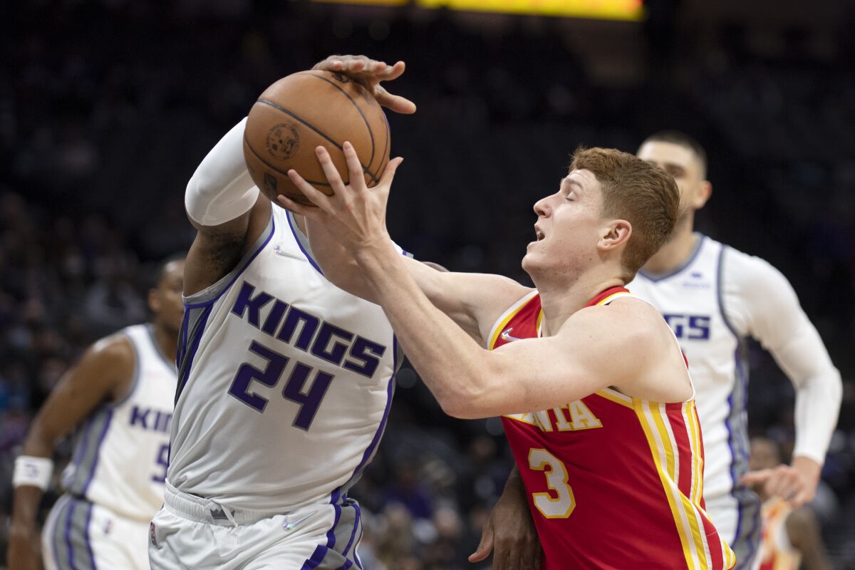 Atlanta Hawks guard Kevin Huerter (3) is defended by Sacramento Kings guard Buddy Hield (24) as he drives to the basket during the first quarter of an NBA basketball game in Sacramento, Calif., Wednesday, Jan. 5, 2022. (AP Photo/José Luis Villegas)