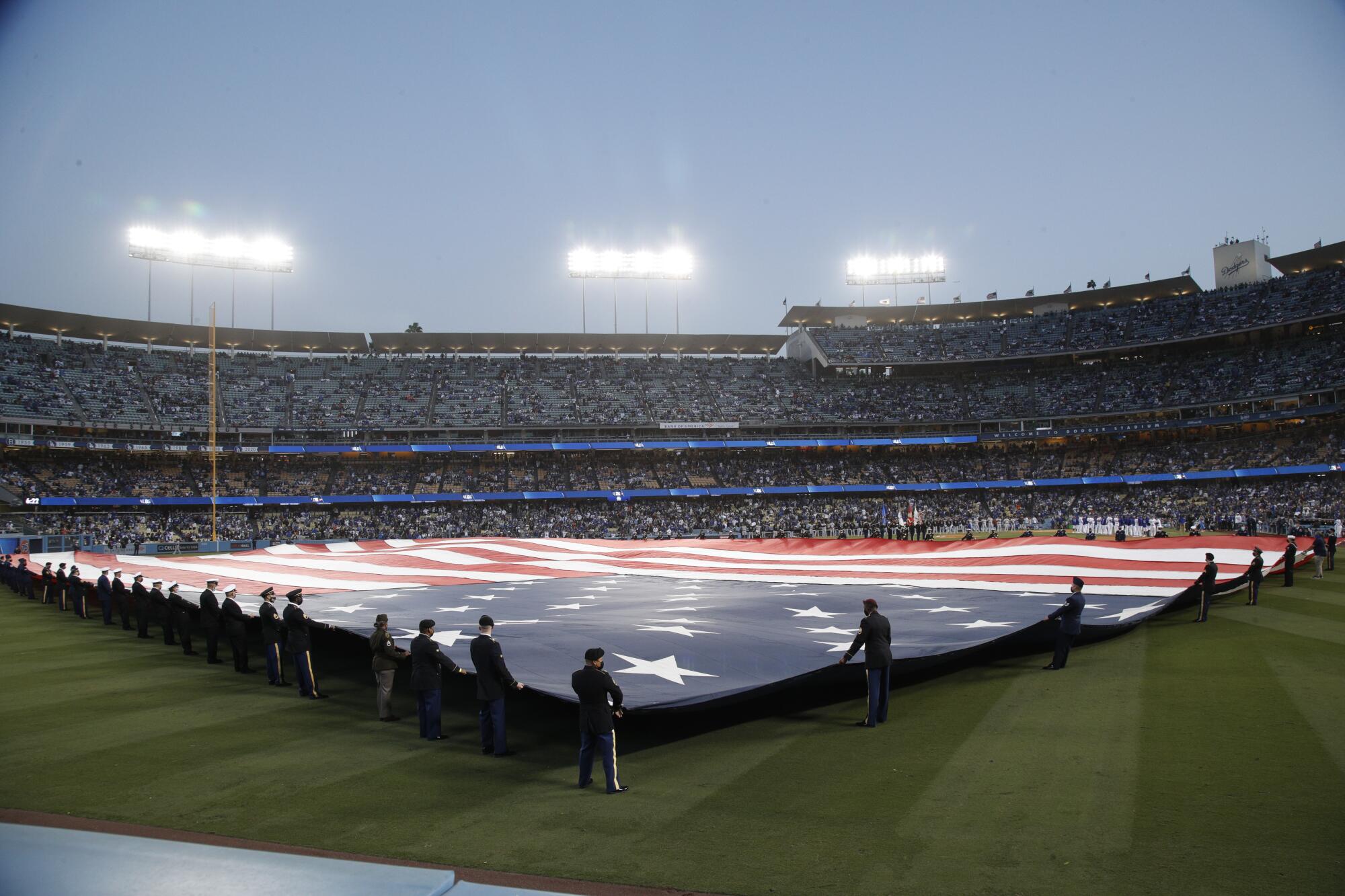 The American flag is displayed in the outfield during the national anthem