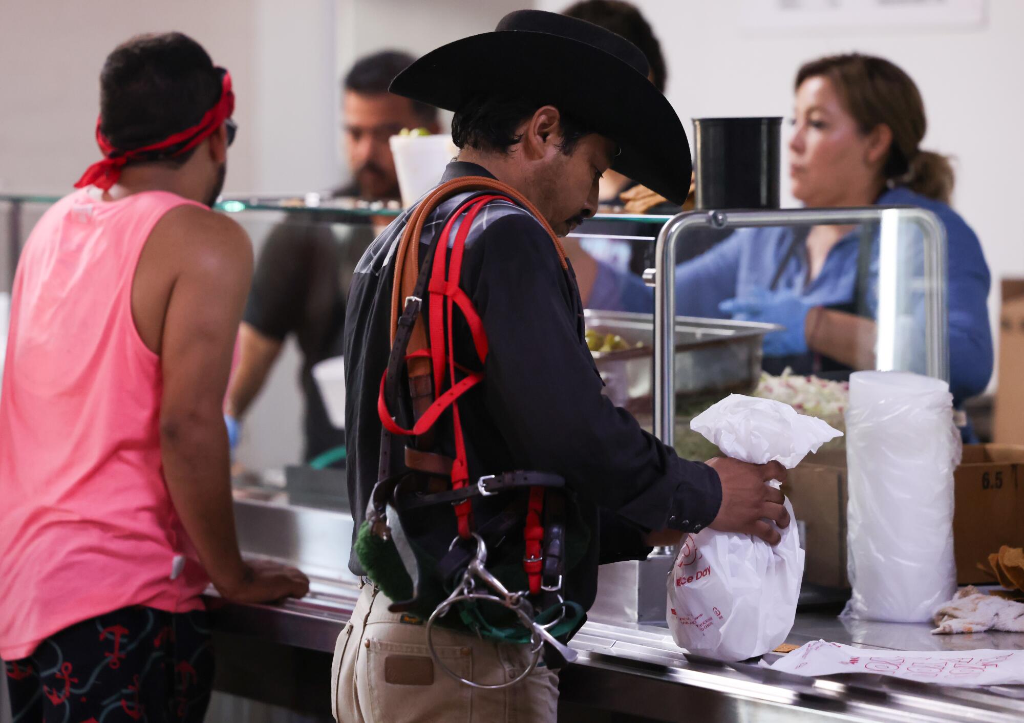 A backstretch worker collects his meal on Aug. 3.