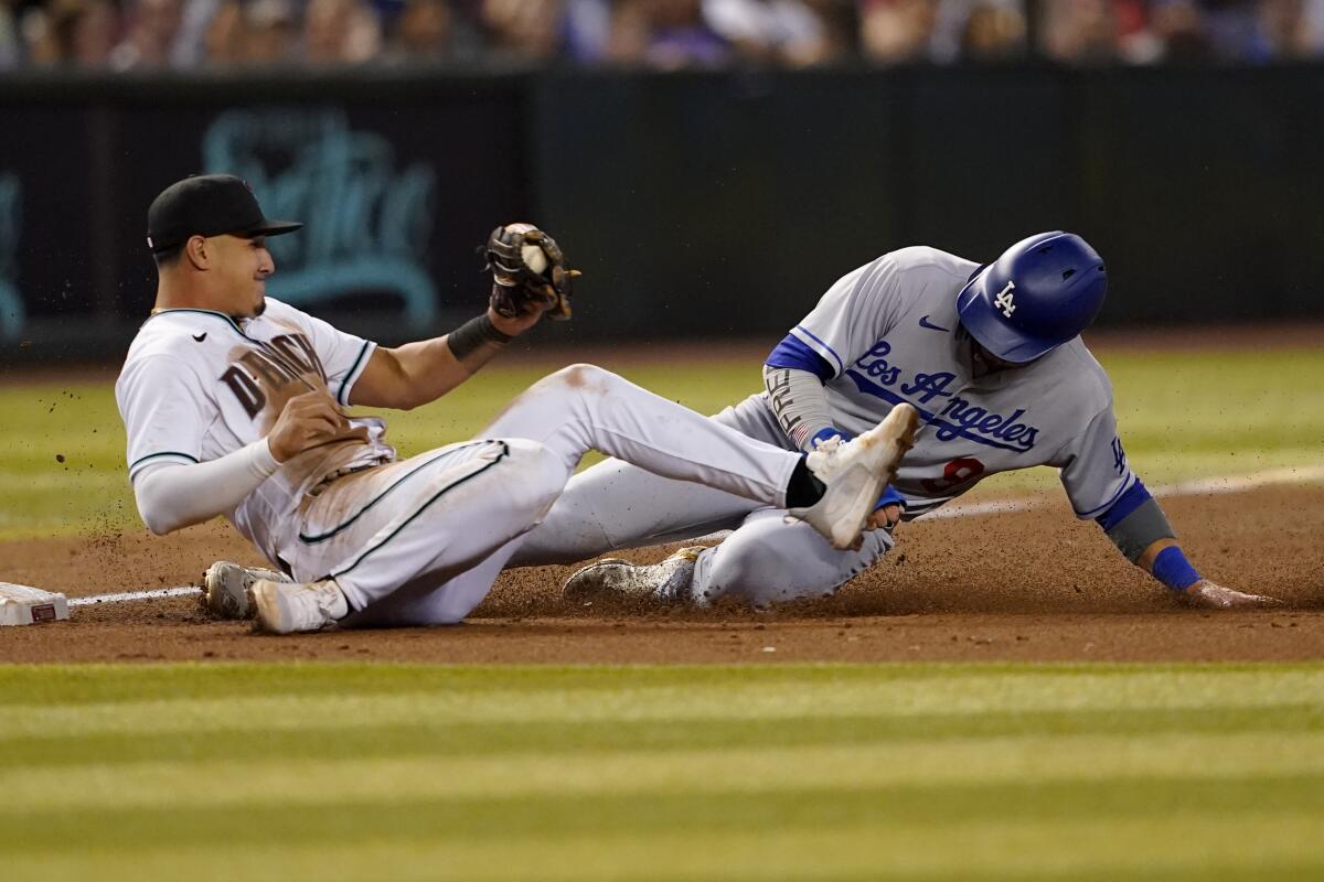 Dodgers' Gavin Lux is caught trying to advance to third by Arizona Diamondbacks' Josh Rojas on a base hit by Mookie Betts.