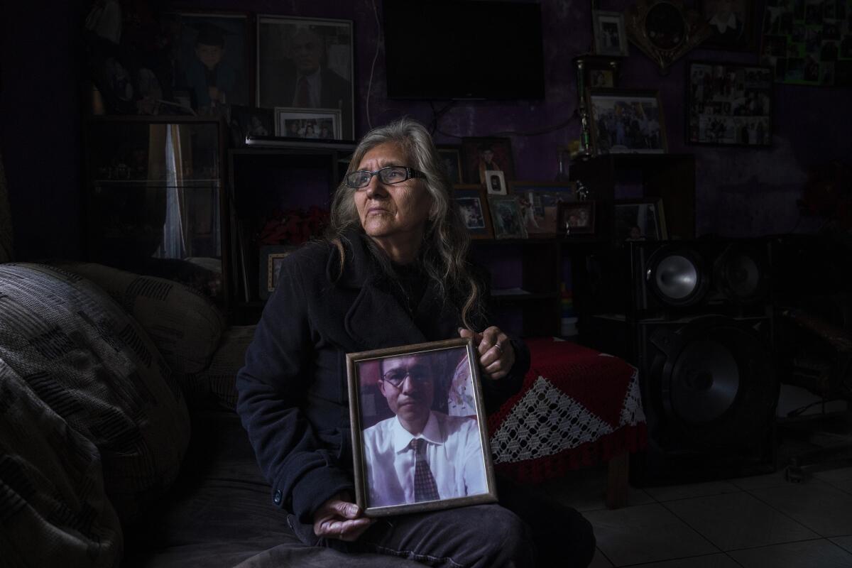 A woman holds a photo of her son 