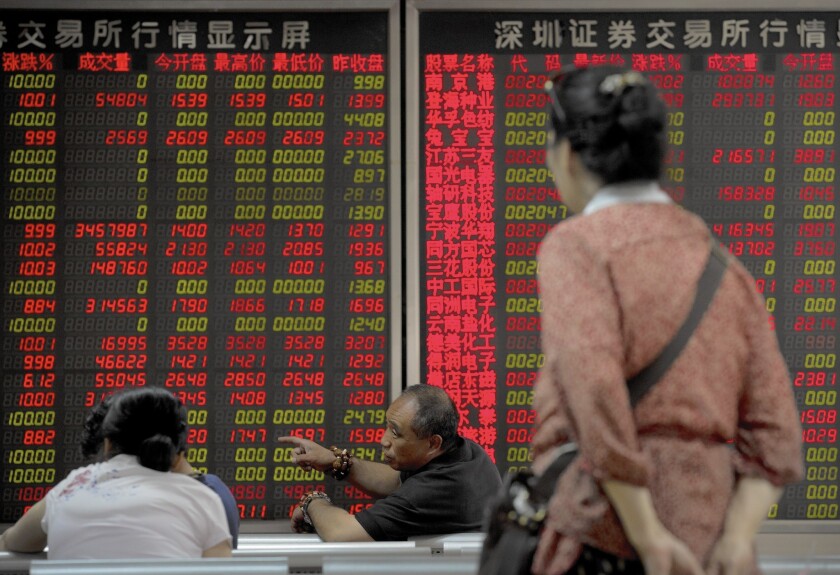 Chinese investors chat while monitoring stock prices at a brokerage house in Beijing on July 13.
