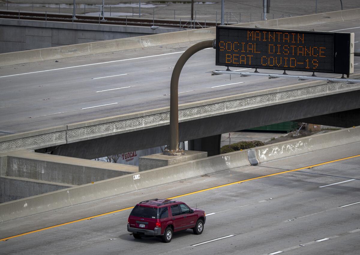 A sign reminds motorists traveling on the 105 Freeway in El Segundo to practice social distancing.