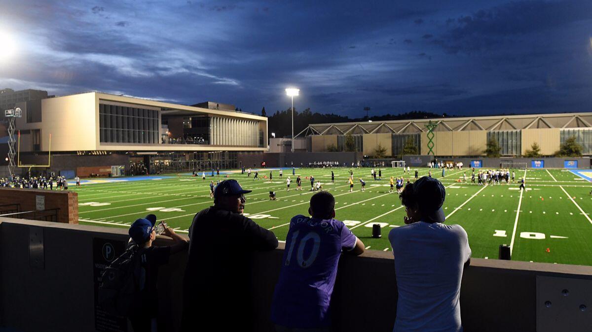 Fans watch football practice from parking lot 8 at the $75-million Wasserman training facilty on the UCLA campus Wednesday.