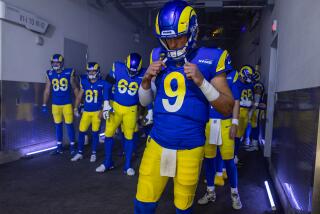 Rams quarterback Matthew Stafford clutches his jersey and prepares to lead the team out the tunnel and onto the field.