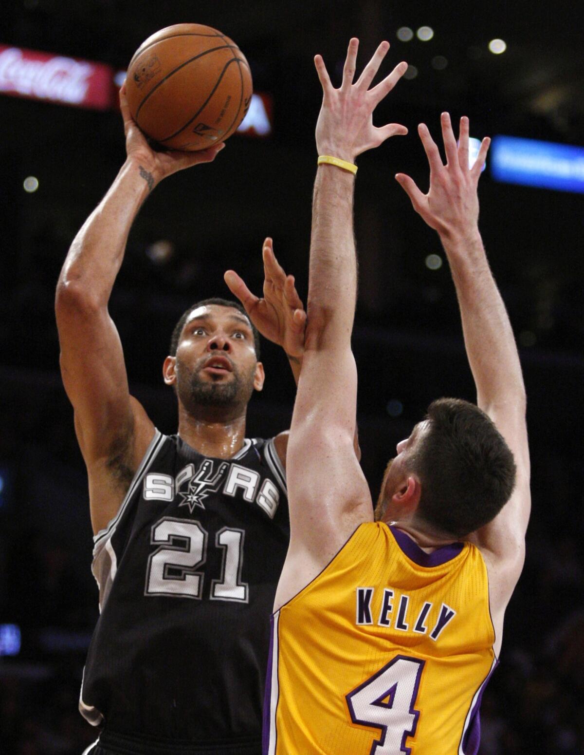 Lakers forward Ryan Kelly stands his ground as Spurs power forward Tim Duncan looks to shoot.