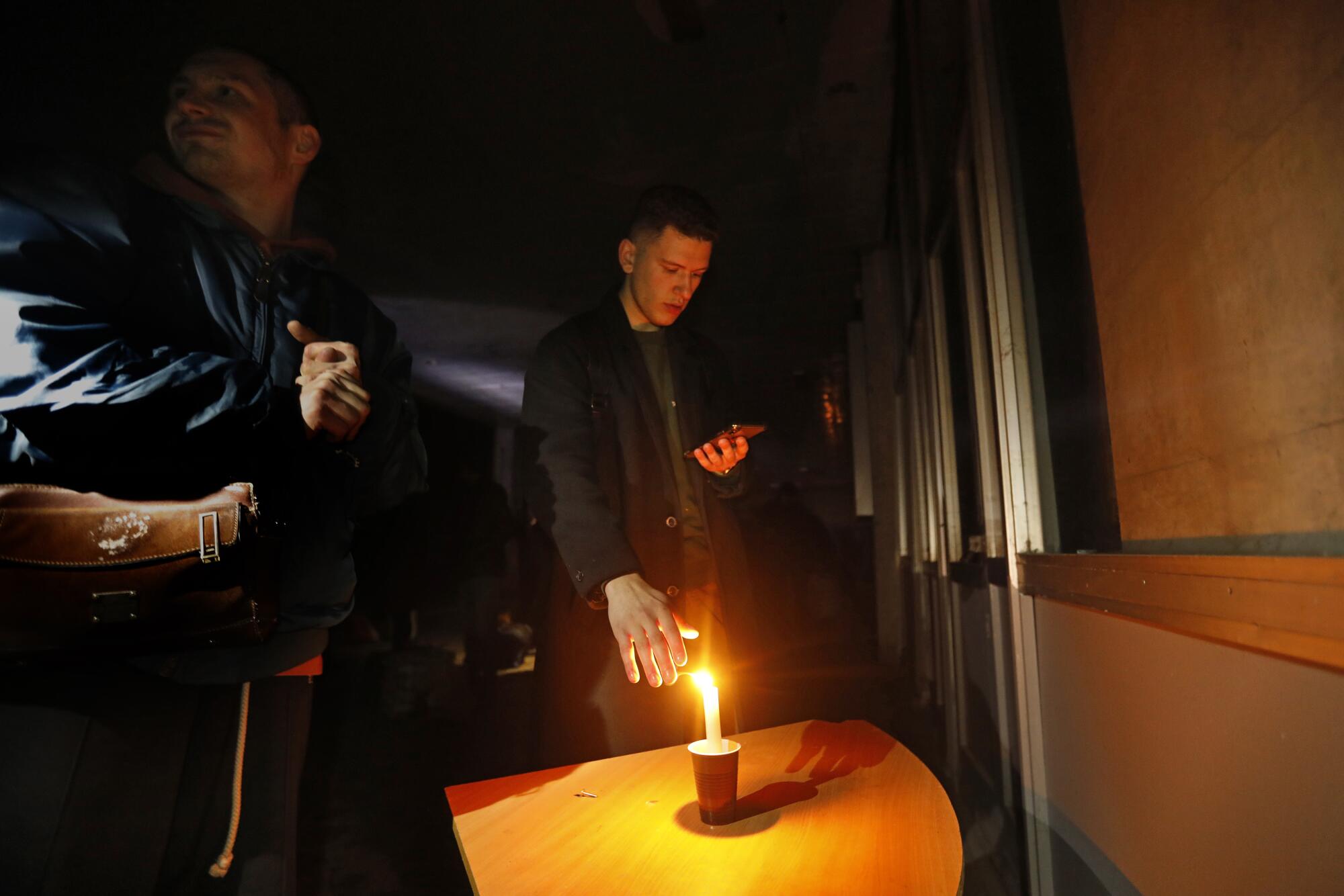 At the train station in Mykolaiv, people wait for the train to Kyiv in the darkness.