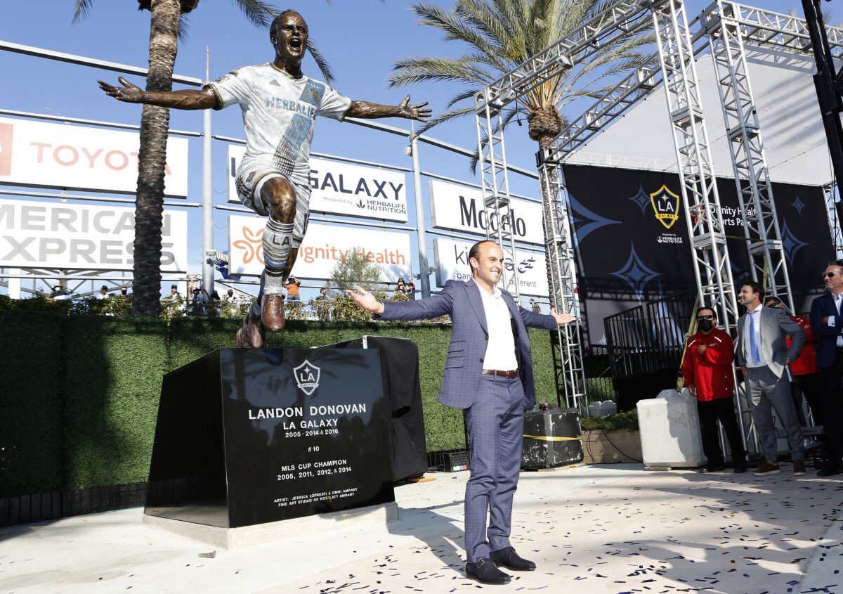 Former Galaxy player Landon Donovan poses in front of his statue Sunday in Carson. 